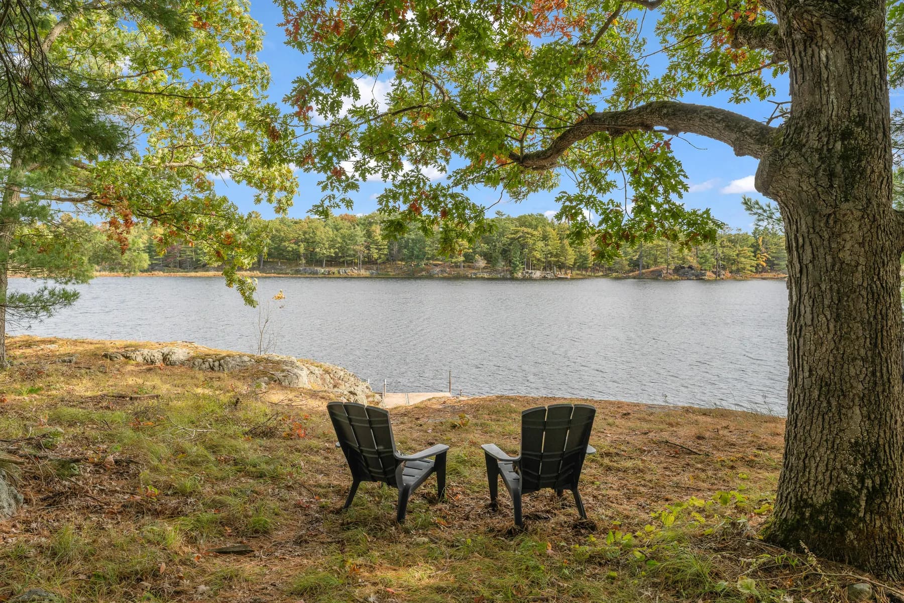 Two chairs on the rocky shoreline overlooking the lake
